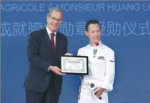  ?? PHOTOS PROVIDED TO CHINA DAILY ?? French Ambassador Maurice Gourdault-Montagne presents Huang Li with the Knight of the Order of Agricultur­al Merit (France) earlier this month.