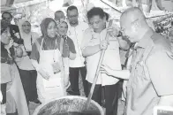  ??  ?? TENGKU Adnan memasak masakan daging di gerai penduduk sempena Sambutan Hari Wilayah Persekutua­n 2017.