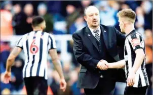  ?? LINDSEY PARNABY/AFP ?? Newcastle manager Rafael Benitez shakes hands with Magpies midfielder Matt Ritchie after their league match with Manchester United on Sunday.