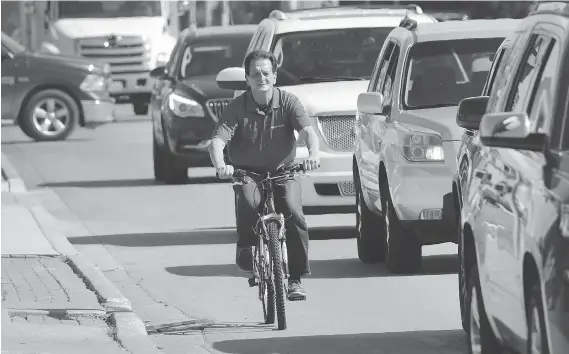  ?? DAN JANISSE ?? Windsor Coun. Paul Borrelli rides his bike Tuesday in the 3000 block of Dougall Avenue. Borrelli wants the city to look into the possibilit­y of cyclists using sidewalks.