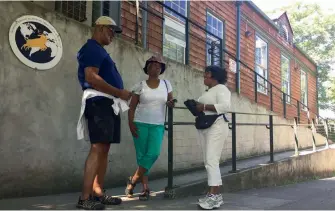  ?? — AP ?? From left, Ron Young, Gahlena Easterly and Sharon Steen reminisce as they take a mile-long walk through North Portland, Oregon streets that once were full of black-owned homes and businesses