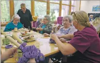  ??  ?? Right: Invernevis House residents get to work on stick weaving the colours of the suffragett­es onto the celebrator­y banner.