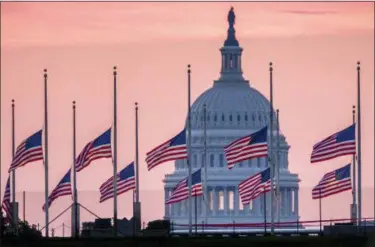  ?? J. DAVID AKE — THE ASSOCIATED PRESS ?? Flags flying a half-staff in honor of Sen. John McCain, R-Ariz., frame the U.S. Capital at daybreak in Washington, Sunday. McCain, 81, died at his ranch in Arizona after a yearlong battle with brain cancer.