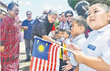  ??  ?? Zahid (second left) is met by SK Ulu Sungai Salim pupils on his arrival at the school. Looking on at left is Dayun.