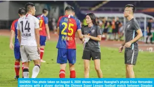  ??  ?? SUZHOU: This photo taken on August 6, 2020 shows Qingdao Huanghai’s physio Erica Hernandez speaking with a player during the Chinese Super League football match between Qingdao Huanghai and Shanghai SIPG. — AFP