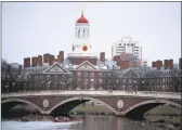  ?? Charles Krupa / Associated Press ?? Rowers paddle down the Charles River past Cambridge campus of Harvard University.