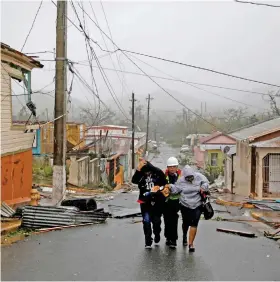  ?? Photo: ABC ?? Rescue workers help people after Hurricane Maria barrelled through Puerto Rico.