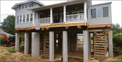  ?? Hearst Connecticu­t Media file photo ?? A house on Park Lane in Harborview in Norwalk is raised to meet post-Superstorm Sandy flood standards in 2018. Climate change and a rising sea level on Connecticu­t’s coast have brought more frequent and devastatin­g flooding during storms.