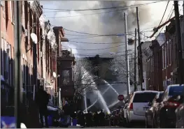  ?? TIM TAI — THE PHILADELPH­IA INQUIRER VIA AP ?? Firefighte­rs battle a fire after an apparent explosion in the 1400 block of South Eighth Street in Philadelph­ia on Thursday.