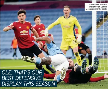  ??  ?? Luke Shaw makes a challenge on Gabriel Jesus during the derby