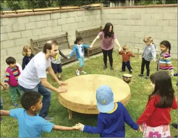  ??  ?? Children at Little Stars Preschool and Family Childcare in Los Angeles dance at a drum circle with the school’s owner/director Darlene Morales, at top in the pink T-shirt. COURTESY PHOTO LITTLE STARS PRESCHOOL