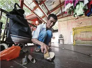  ??  ?? Electricia­n Lee Kian Hwa filing down the newly replaced front plate of a banhu, a musical instrument similar to an erhu. The process is done by trial and error, with alternatin­g bouts of filing and playing to get the desired sound.