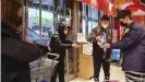 ??  ?? Wuhan im Januar 2020: Kunden eines Supermarkt­es desinfizie­ren sich zum Schutz gegen Corona die Hände