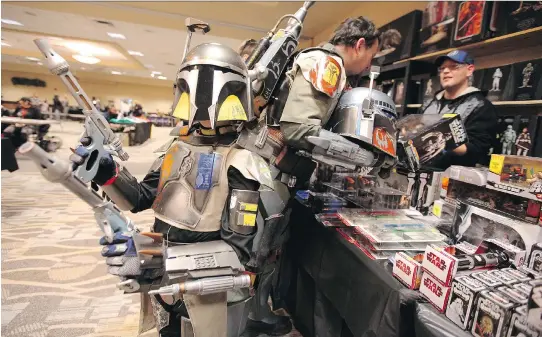  ?? JASON HALSTEAD/FILES ?? Fans in Boba Fett costumes shop for Star Wars items at a comic and toy event in Winnipeg. Star Wars products have become the largest toy property in history.