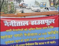  ?? PTI PHOTO ?? A banner reading Nainital has shut its parking for tourists arriving in their vehicles as it is houseful.