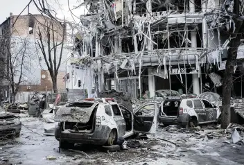  ?? PAVEL DOROGOY AP ?? Damaged vehicles sit among debris Wednesday in central Kharkiv, Ukraine. Emergency response officials in Kharkiv described intense and indiscrimi­nate Russian shelling that filled morgues and depleted the supply of body bags.