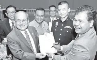  ??  ?? Ik Pahon (right) signs the integrity pledge held by Uggah (left), while Chang (second right) and others look on.