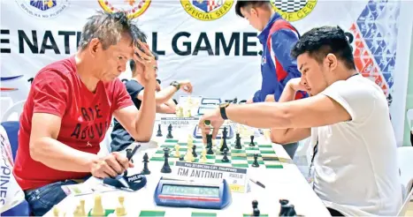  ?? MACKY LIM ?? UPSET. Davao City's Fide Master (FM) Austin Jacob Literatus, 19th-seed, right, moves against second-seed grand master Rogelio “Joey” Antonio, Jr. of Calapan, Oriental Mindoro enroute to winning their second round match in 51 moves of an Alekhine...