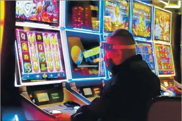  ?? WAYNE PARRY — THE ASSOCIATED PRESS ?? A man wears a face shield while playing a slot machine at the Golden Nugget casino in Atlantic City, N.J., on July 2. A report released Monday by the national trade associatio­n for the U.S. casino industry found that America’s casinos won 81% of the amount of money during the third quarter of this year compared to the third quarter of 2019.