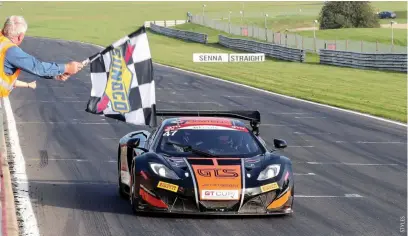  ??  ?? GT Cup stalwart Richard Chamberlai­n waves the flag as Davidson wins race three