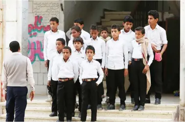  ??  ?? Yemeni children, formerly Houthi fighters, are pictured outside a rehabilita­tion centre at a school in the town of Marib. (AFP)