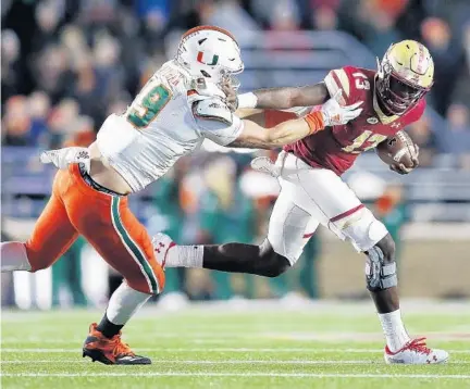  ?? MICHAEL DWYER/AP ?? Boston College quarterbac­k Anthony Brown eludes a tackle by Miami defensive lineman Scott Patchan during the first half of Friday’s game.