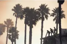  ?? JAE C. HONG/ASSOCIATED PRESS ?? Three firefighte­rs stand on the rooftop of a beach house to water down the property while they battle a wildfire at Faria State Beach in Ventura, Calif., on Thursday.