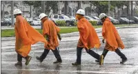  ?? LANNIS WATERS / THE PALM BEACH POST ?? Constructi­on workers cross Lakeview Avenue in downtown West Palm Beach as the rain slacks up from a storm passing through Friday.