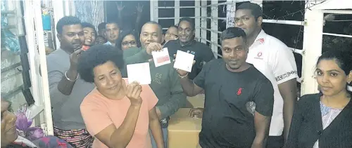  ??  ?? Victims of the Nabua Muslim League Settlement blaze with their brand new e-ticketing cards with a Vodafone staff member on October 20, 2017.