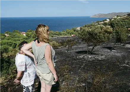  ?? PERE DURAN / NORD MEDIA ?? Uns veïns observant la zona arrasada pel foc, que va causar ferides lleus a dos bombers i a un ADF