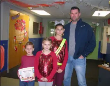  ?? KEVIN TUSTIN - DIGITAL FIRST MEDIA ?? The Hoback family at Primos Elementary School’s special Veterans Day assembly. James served with the U.S. Marines and did tours in Iraq. He was honored by his children, from left, Nathan, Taylor and Calista.