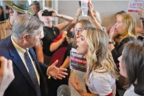  ?? AP PHOTO/GEORGE WALKER IV ?? Johnny Ellis, left, argues Aug. 29 over gun law reform with Covenant School parent Mary Joyce outside the House chamber after special session on public safety adjourned in Nashville.