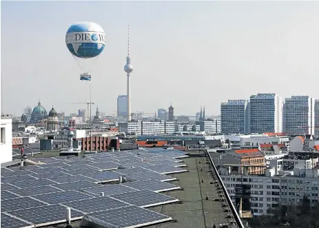  ?? Bloomberg ?? Sunny side up: Solar panels on the roof of the Europahaus in Berlin, Germany. The winners in the new model of energy provision will be those who invest in the value chain of the emerging sector, the writer says. /