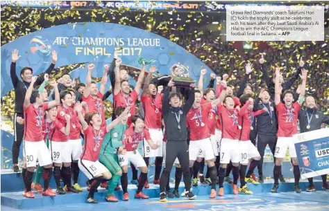  ?? — AFP ?? Urawa Red Diamonds’ coach Takafumi Hori (C) holds the trophy aloft as he celebrates with his team after they beat Saudi Arabia’s Al Hilal to win the AFC Champions League football final in Saitama.