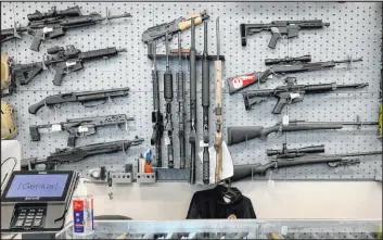  ?? Andrew Selsky The Associated Press ?? Firearms are displayed at a gun shop in Salem, Ore., in 2021. An Oregon judge has ruled that a voter-approved gun control law violates the state constituti­on.