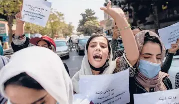  ?? BULENT KILIC/GETTY-AFP ?? Afghan protesters hold placards during a demonstrat­ion to demand better rights for women Sunday in Kabul near the former Women’s Affairs Ministry, an agency that was shuttered by the Taliban last week.