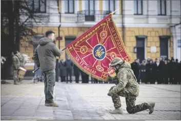  ?? UKRAINIAN PRESIDENTI­AL PRESS OFFICE ?? UKRAINIAN PRESIDENT VOLODYMYR ZELENSKYY holds the flag of a military unit as an officer kisses it during commemorat­ive event on the occasion of the Russia Ukraine war one year anniversar­y in Kyiv, Ukraine, on Friday.