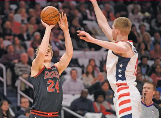  ?? NICK WASS/AP ?? Lauri Markkanen shoots against Davis Bertans in the first half Wednesday. Markkanen led the Bulls with 31 points, shooting 12-for-19 from the field.
