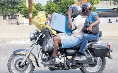  ?? FILE ?? In this 2015 photo a motorcycli­st and the pillion rider are seen loaded with goods.