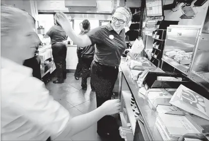  ?? PHOTOS JIM WEBER/THE COMMERCIAL APPEAL ?? Employee Sara Seals greets a regular customer while filling orders at the Chick-fil-A at 4916 Poplar Ave. The American Customer Satisfacti­on Index 2015 restaurant report gives the Atlanta-based chain a score of 86 out of a possible 100, the highest...