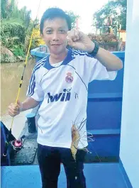  ??  ?? PENULIS bersama hasil pancingan di Sungai Muanad.