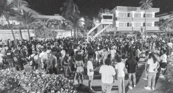  ?? D.A. VARELA dvarela@miamiheral­d.com ?? Crowds gather at Ocean Drive and Eighth Street during spring break in Miami Beach on March 18, 2023.