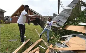  ?? (AP/Thomas Graning) ?? Derrick Pounds and his daughter, Madison, 6, clean up debris Monday outside their home on Elvis Presley Drive in Tupelo, Miss.