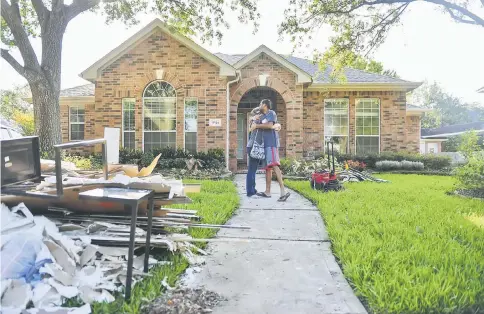  ??  ?? Nash and Stephanie Ubale embrace after meeting with contractor­s at their flood-damaged home in Houston.