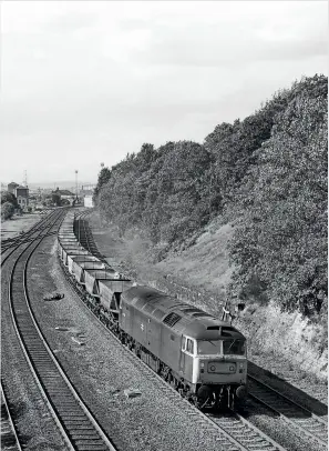  ??  ?? RIGHT: Class 47/3 47373 enters Horbury cutting as it heads east from Healey Mills Yard on September 11, 1981 with a rake of empty
HAA wagons. The loco was one of two
fitted with a roof mounted warning light to notify staff when it was being remote controlled at
collieries. (Rail Photoprint­s/
John Chalcraft)