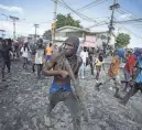  ?? ODELYN JOSEPH/AP ?? A protester carries a piece of wood simulating a weapon during a protest in Port-au-Prince, Haiti, Oct. 3.