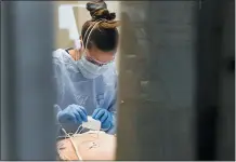  ??  ?? East Alabama Medical Center nurse Abby Smith works on a COVID-19 patient.