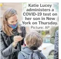  ?? Picture: AP ?? Katie Lucey administer­s a COVID-19 test on her son in New York on Thursday.