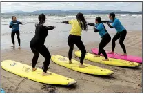  ?? The New York Times/THERESE AHERNE ?? New surfers learn techniques in a surfing class at Rossnowlag­h, Ireland. The long sandy beach there is a popular spot for beginner and intermedia­te surfers.
