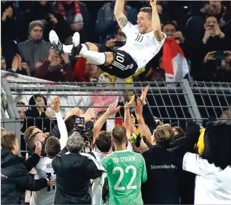  ?? FRANK AUGSTEIN/AP ?? AUF WIEDERSEHE­N: Lukas Podolski dilempar ke udara setelah pertanding­an Jerman versus Inggris di Signal Iduna Park (23/3). Podolski mengakhiri karir internasio­nalnya dengan 130 caps dan 49 gol.